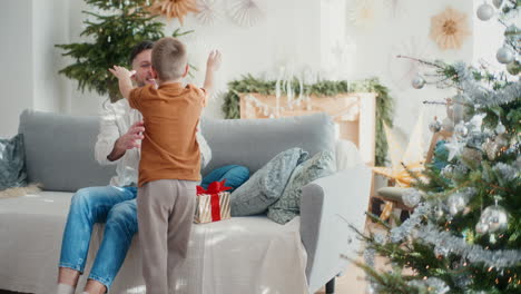 little boy and his dad prepare christmas decorations and presents