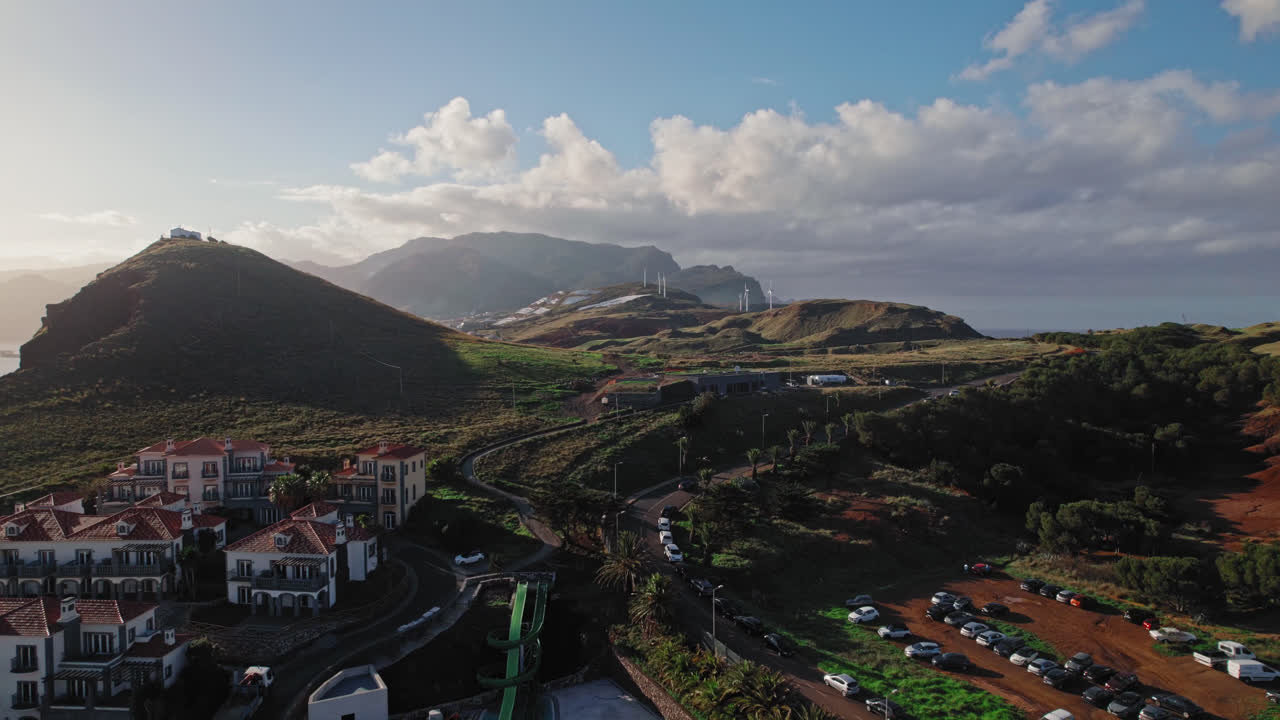 Coastal Resort with Mountain Views and Wind Turbines