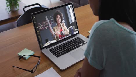 Mujer-Afroamericana-Haciendo-Una-Videollamada-Con-Una-Colega-De-Oficina-En-Una-Computadora-Portátil-En-Casa