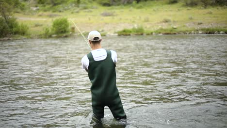 Schuss-Eines-Kaukasischen-Männlichen-Fischers,-Der-Seinen-Haken-Beim-Fliegenfischen-Wirft