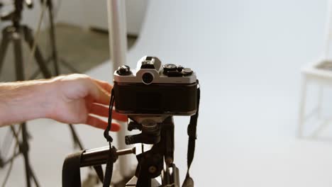 fotógrafo masculino ajustando la cámara en el estudio fotográfico 4k
