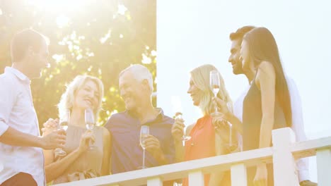 Freunde-Interagieren-Miteinander,-Während-Sie-Auf-Dem-Balkon-Champagner-Trinken