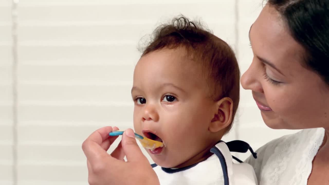 Happy mother feeding her baby boy