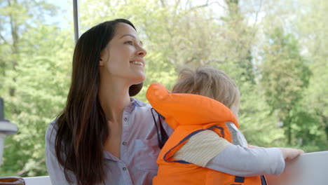 mother and son enjoy ride in river boat shot in slow motion