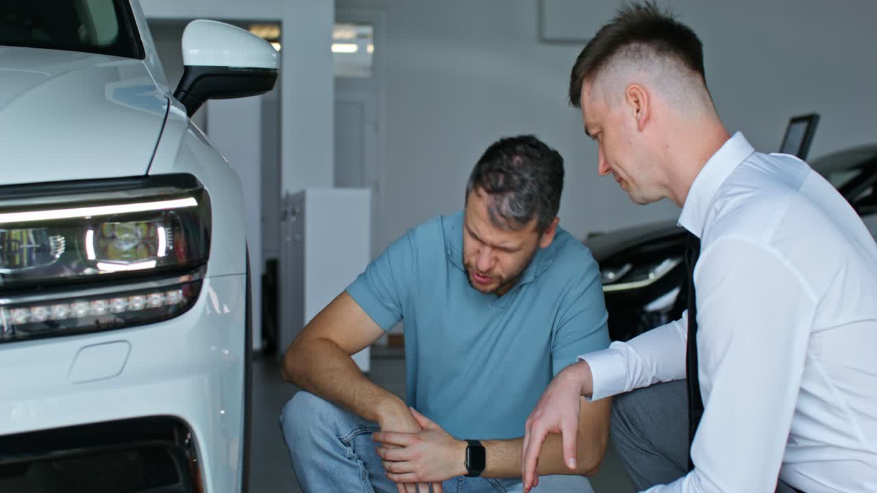 cliente y vendedor discutiendo un coche en un concesionario