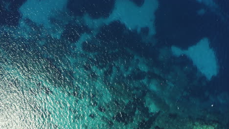 vista aérea despegando lentamente sobre el arrecife del océano en mykonos grecia con varias gaviotas flotando en la brisa