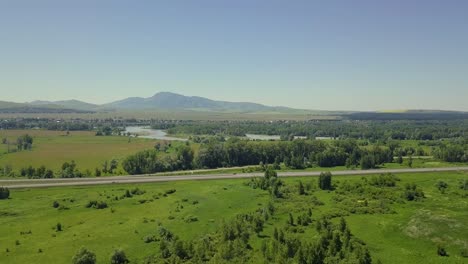 aerial flying over the highway forest and field view of the tourist city mountain river