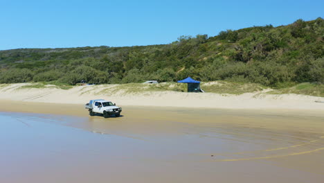 4WD-Car-Driving-Along-Sandy-Beach-Past-Camp-Sites-On-Double-Island-Point,-Queensland,-4K-Drone