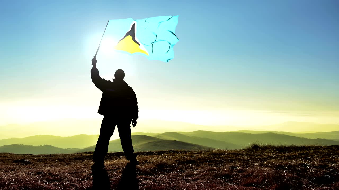 hombre ganador de silueta exitosa agitando la bandera de santa lucía en la cima de la montaña, fondo de bucle de cinemagraph