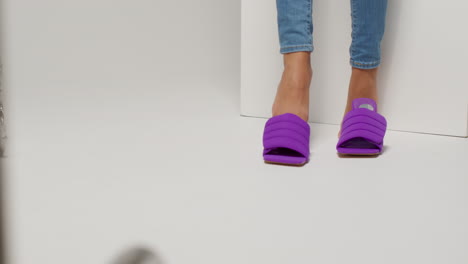 close up of female social media influencer producing user generated content putting on beautiful pair of purple shoes