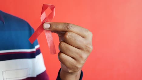 hand holding red hiv ribbon with copy space