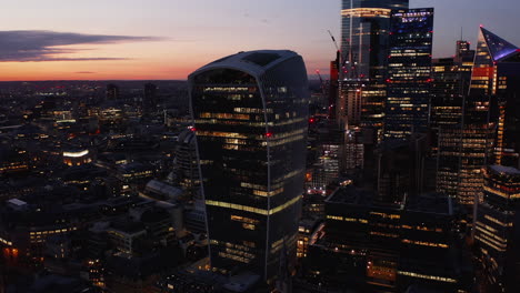 Dia--Und-Schwenkaufnahmen-Von-Modernen-Futuristischen-Bürogebäuden-Im-Finanzzentrum-Der-Stadt-Nach-Sonnenuntergang.-Kultiger-Walkie-Talkie-Wolkenkratzer-Mit-Himmelsgarten-Unter-Dach-Gegen-Dämmerungshimmel.-London,-Vereinigtes-Königreich