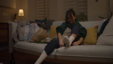 woman relaxing on sofa at night