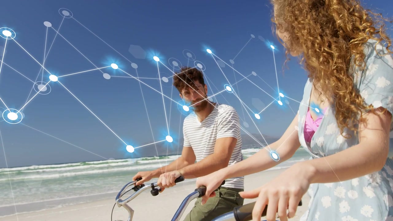 Kamera oddalająca się, z pojawiającą się grafiką sieci technologicznej, para na plaży wskazująca i planująca rejs wycieczkowy