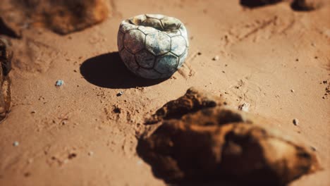 vieja pelota de fútbol en la playa de arena