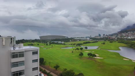 Time lapse of fog clearing over a golf course, revealing Cape Town Stadium and the city.