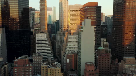 High-rise-buildings-in-midtown-at-dusk.-Tall-office-towers-illuminated-by-setting-sun.-Manhattan,-New-York-City,-USA