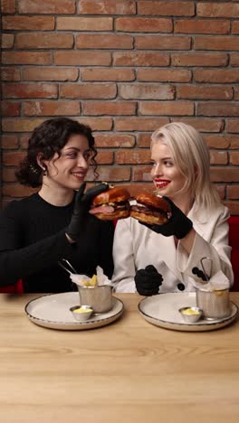 two women enjoying burgers in a restaurant