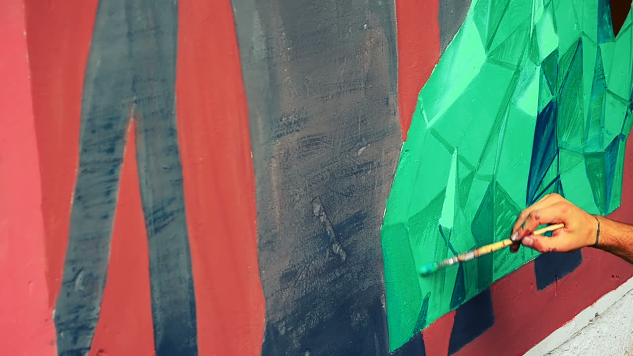 L'artista realizza graffiti su una recinzione. Disegno astratto