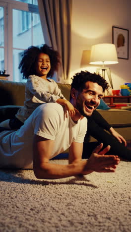 joyful father and daughter playing together at home