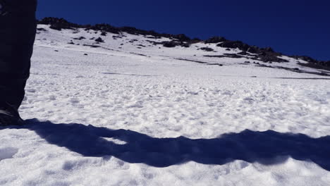 Wanderer-Aus-Niedrigem-Winkel-Geht-Von-Schneebedecktem-Bergrücken-Zur-Kamera,-Blauer-Himmel