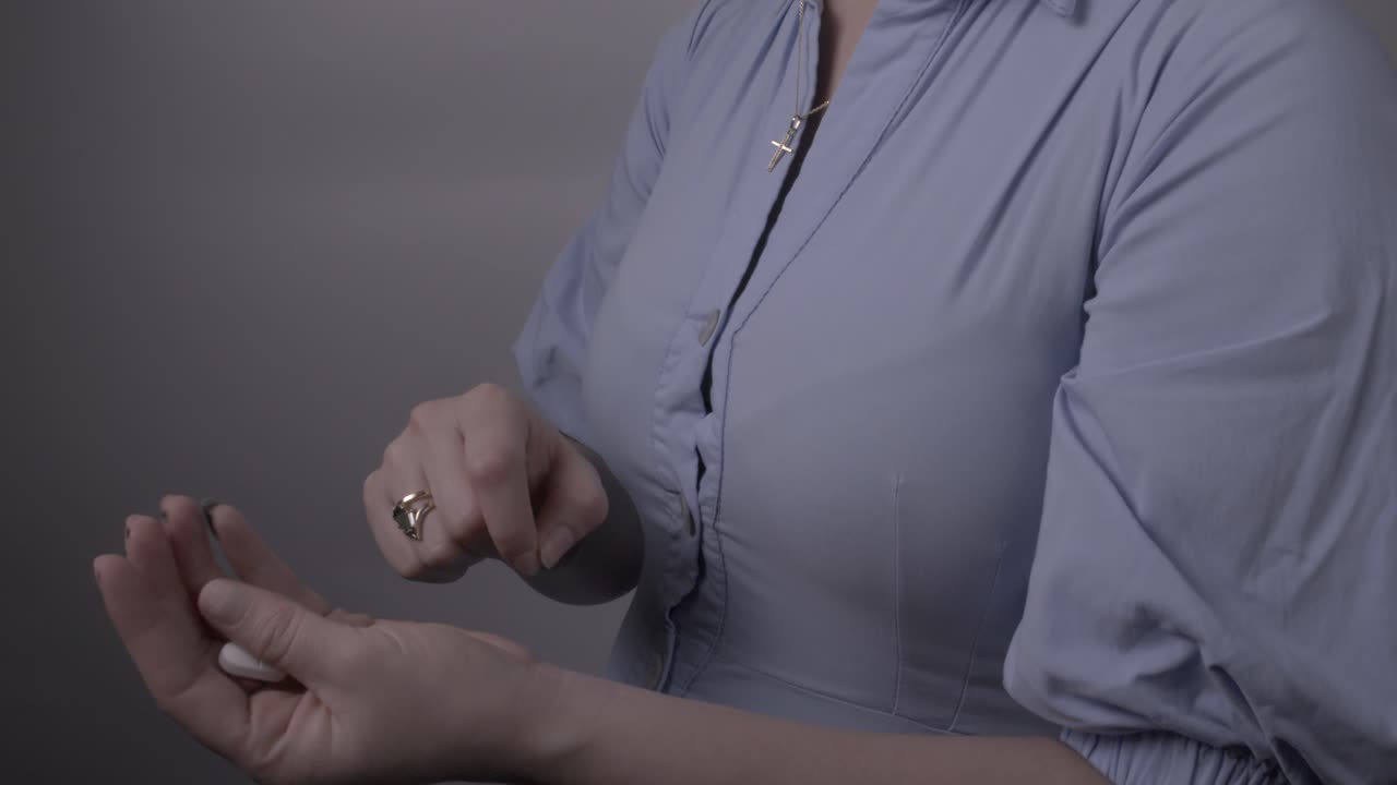 A woman chooses and takes a pill as part of her medical treatment
