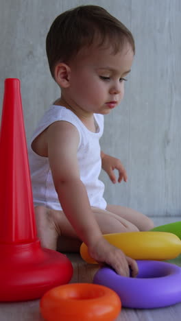 toddler playing with colorful rings and cones