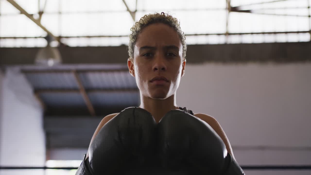mujer de raza mixta con guantes de boxeo