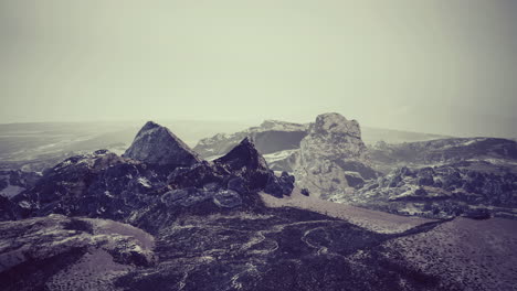 majestuosas formaciones rocosas en un remoto paisaje montañoso bajo una luz suave