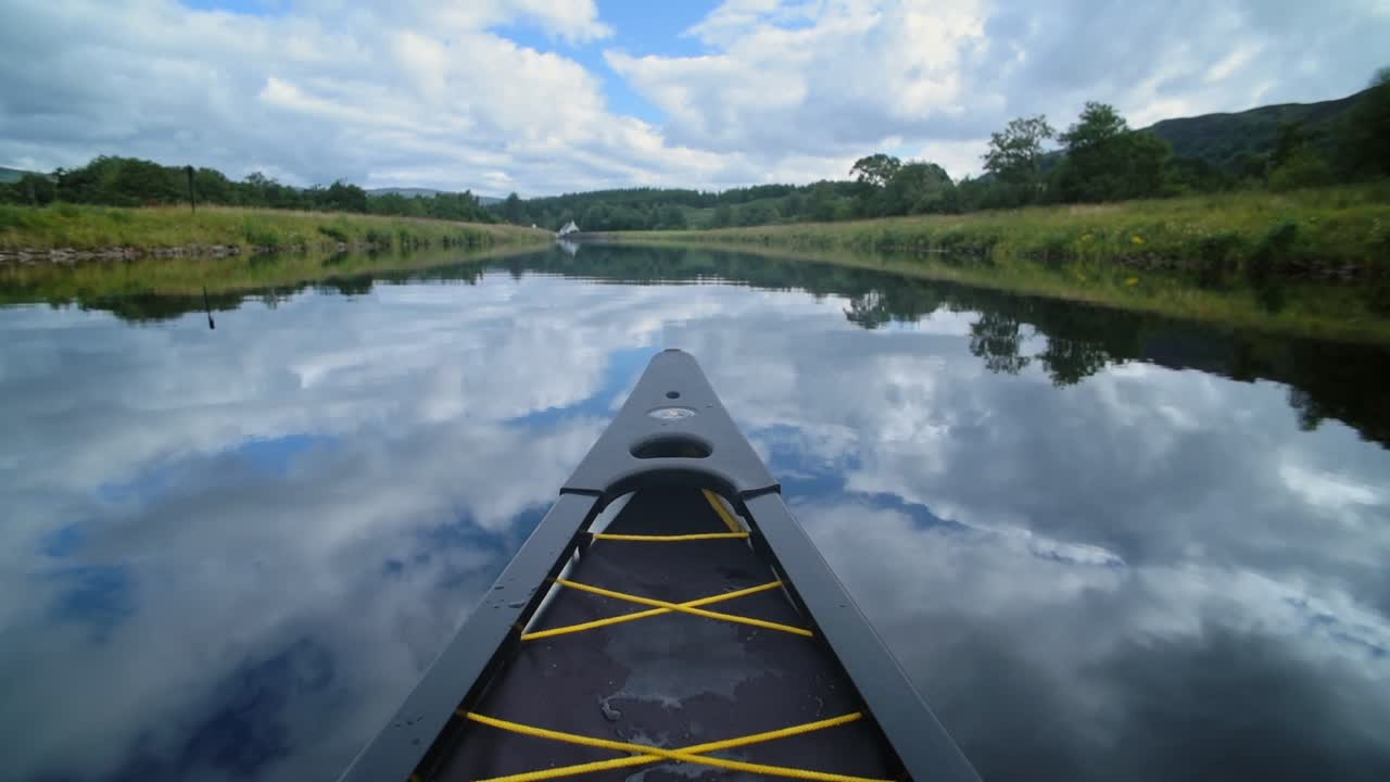 The Tip Of The Boat Sailing Through The Caledonian Canal Under A Clear Blue Sky. -wide shot
