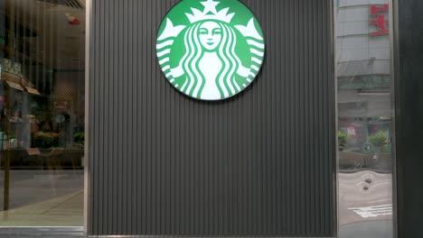 the logo of starbucks, the american multinational coffee chain, is prominently displayed outside its store in hong kong, china.