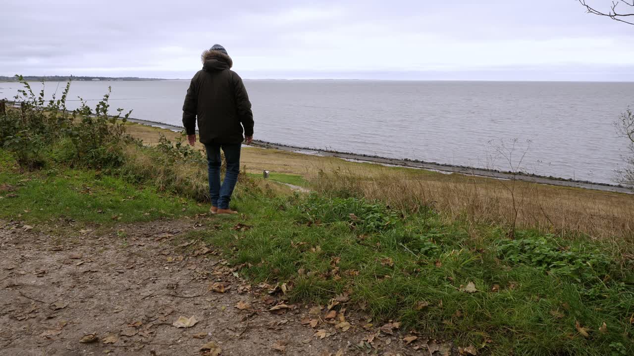un hombre bien vestido camina cerca del mar, en sylt, una isla en alemania.