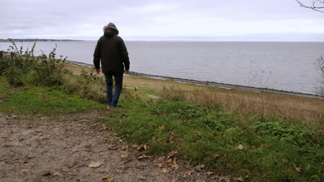 warmly dressed man walks near the sea, on sylt, an island in germany