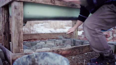 man laying concrete block and putting cement using a finishing trowel