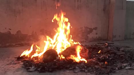 a closeup shot of fire burning outside at night on the terrace roof