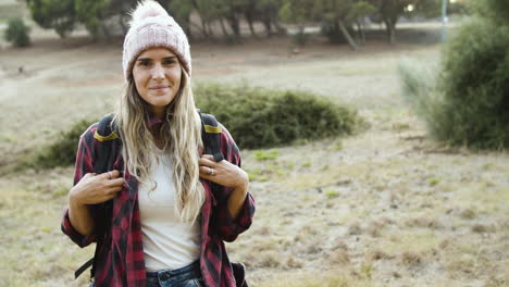 Happy-camping-girl-wearing-woolen-hat-posing-in-the-countryside