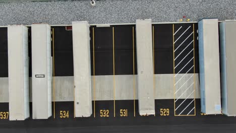 Top down birds eye aerial, shipping trailers containers parked in distribution center depot, numbered spaces, logistics freight theme