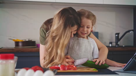 mother-smiles-and-kisses-her-young-daughter