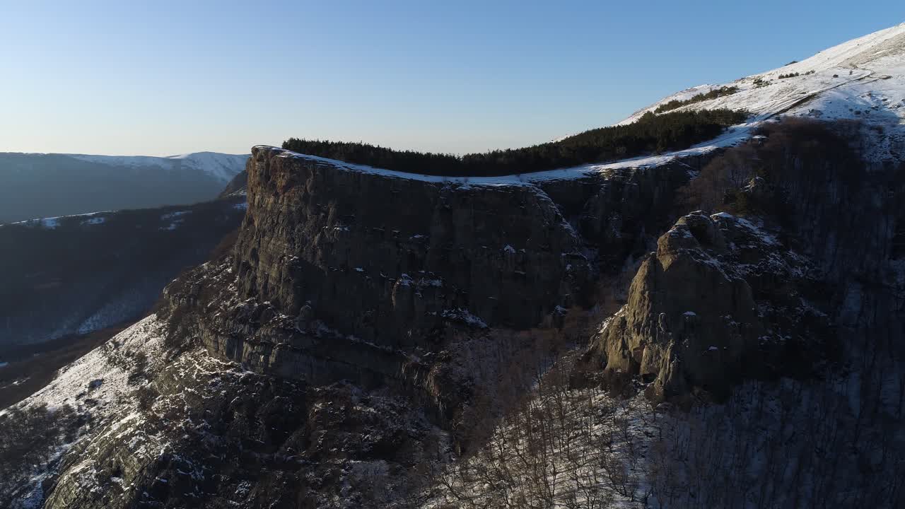 눈 인 산꼭대기와 절벽이 있는 겨울의 산악 풍경