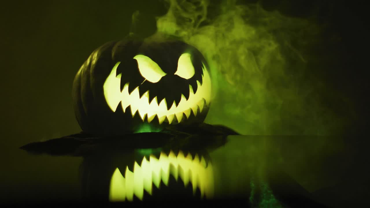 video de calabaza tallada de halloween con humo y luz verde sobre fondo negro