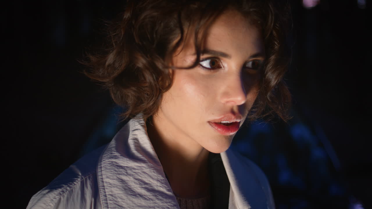 mujer misteriosa posando oscuridad iluminada luz primer plano. modelo por la noche