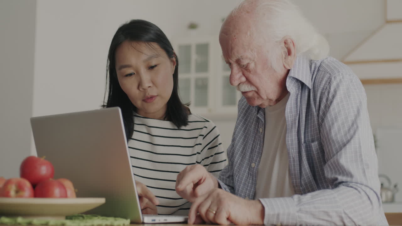 Senior Man Learning to Use Laptop with Assistance
