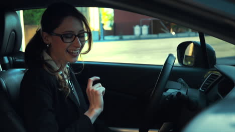 attractive caucasian business woman in a parked car while talking on the phone, she smiles and laughs during her conversation