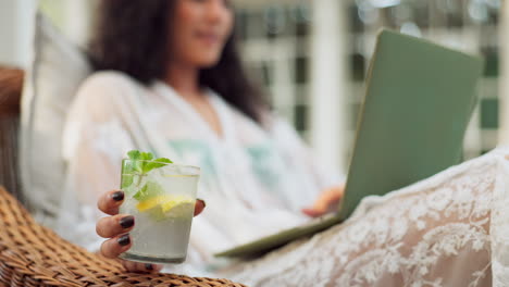 woman relaxing with cocktail and laptop
