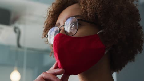 vista de cerca de una mujer afroamericana pensativa que usa una máscara facial con la mano en la barbilla en el moderno off