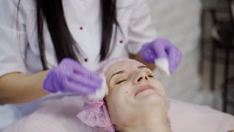 Young beautiful woman receiving facial massage and spa treatment. Cosmetology.