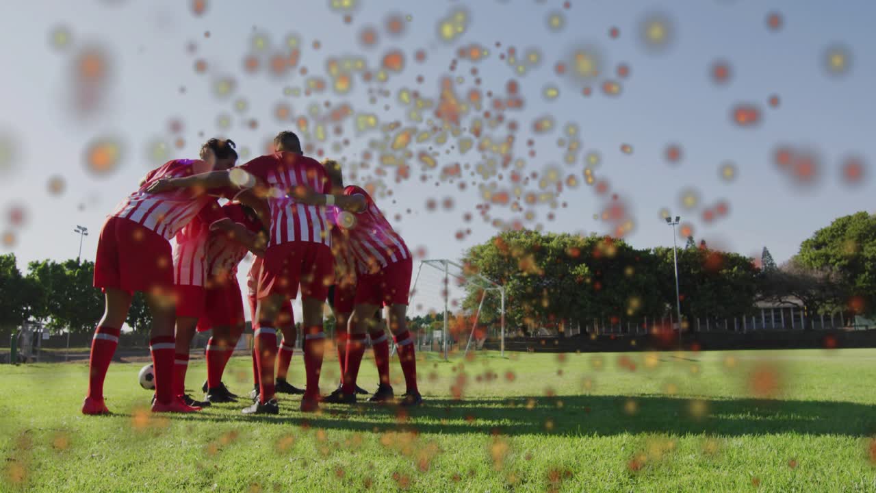 Sports team forming huddle pre-match, chanting for unity while confetti particles swirling overhead