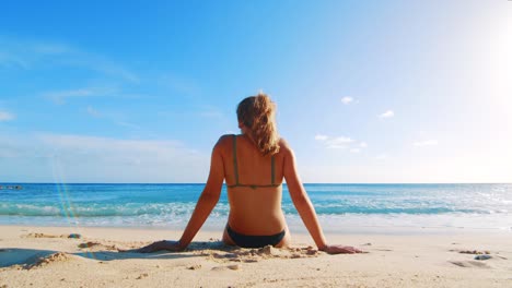 Niña-Sentada-En-Una-Playa-Y-Ella-Hace-Un-Pequeño-Movimiento-Y-Su-Cabello-Se-Mueve