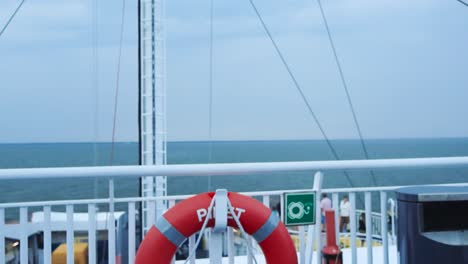 slowly moving footage of view from the ferry deck with red lifebuoy while ferry is travelling on blue sea from route between the estonian mainland and the island muhu, saaremaa in 4k during summer.