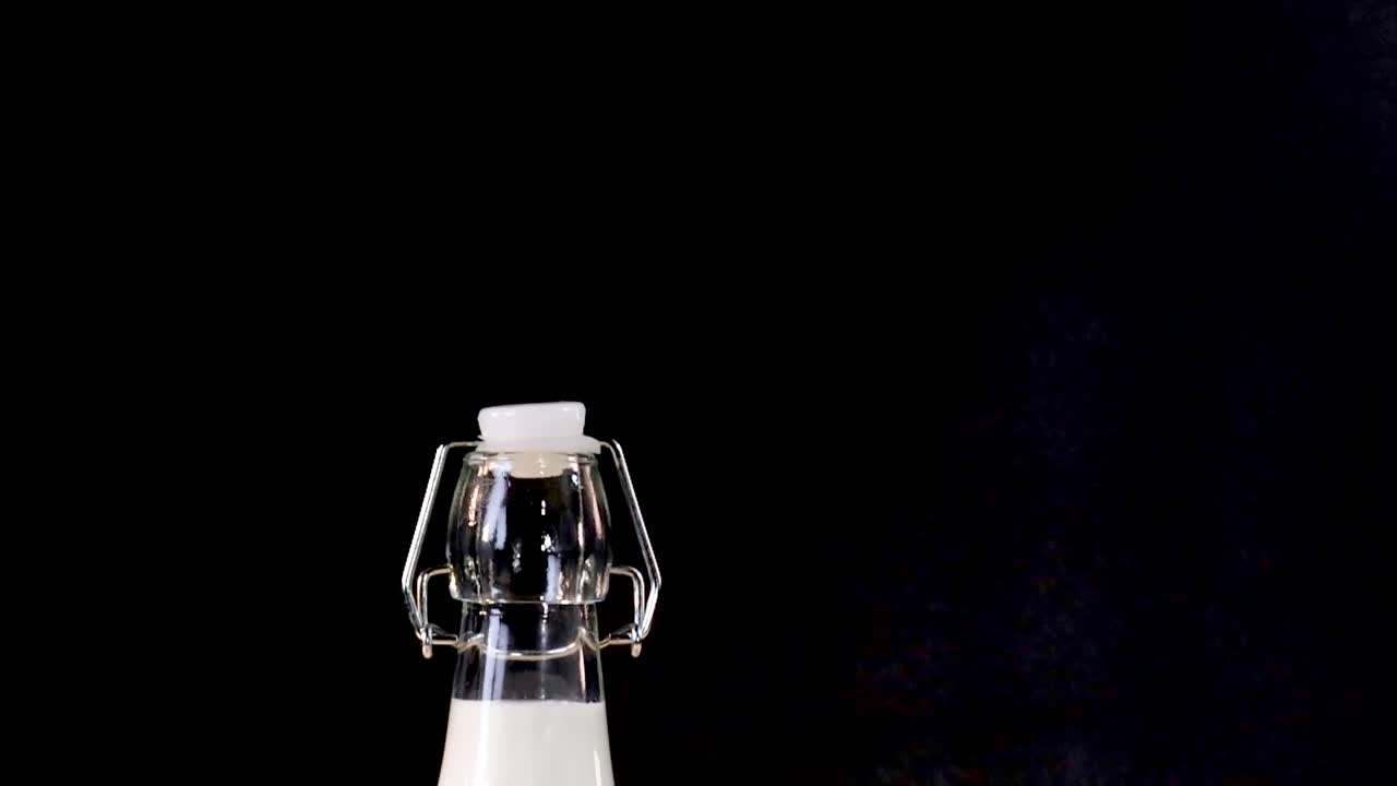 A variety of dairy bottles and cheese wedges arranged on a dark background.